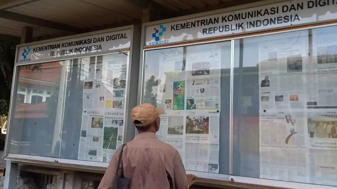Slamet menikmati asupan informasi melalui lembaran koran yang dipajang di majalah dinging (mading) Monumen Pers Nasional di Surakarta, pada Senin (8 Juni 2026). (Sumber: The Stance/Mohamad Hidayah Al Fajri) koran mading