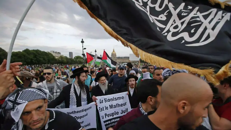 Anggota kelompok Yahudi Ultra-Ortodoks Neturei Karta, yang menentang Zionisme dan negara Israel, memegang spanduk bertuliskan "Zionisme adalah Kemalangan bagi Bangsa Yahudi" sementara spanduk syahadat terlihat di sebelah kanan, di Paris, Prancis, Rabu (23/7/2014) selama demonstrasi memprotes penembakan tentara Israel di Gaza. (Foto AP/Francois Mori) demo anti Israel