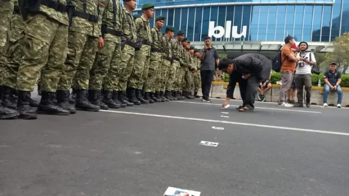 Peserta aksi menempelkan stiker Wakil Presiden Gibran Rakabuming Raka di depan sejumlah aparat TNI yang berjaga di Jalan Jenderal Sudirman, tepatnya di depan Gedung UOB, Jakarta Pusat, Rabu (28/10/2026). (Foto: Republika) tni - demo