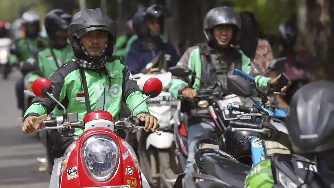 Pengemudi Go-Jek menunggu pelanggan di Jakarta, Indonesia, Kamis, 24 Mei 2018. (AP Photo/Achmad Ibrahim) Gojek